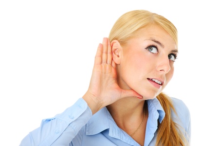 A picture of a young woman listening with attention over white backgroundの写真素材