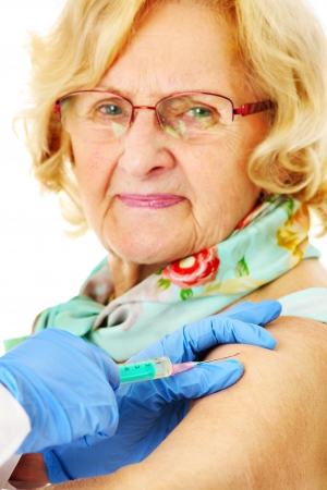 A portrait of a senior woman being given a shot in the armの写真素材