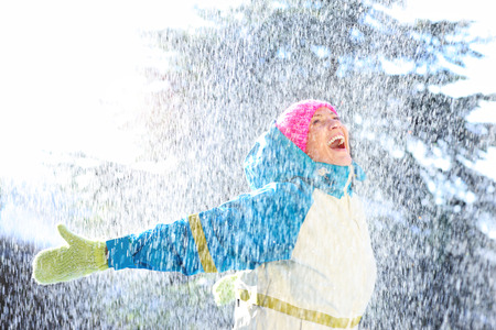 A picture of a joyful woman playing in the snow