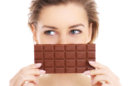 A picture of a pretty woman holding chocolate over white の写真素材