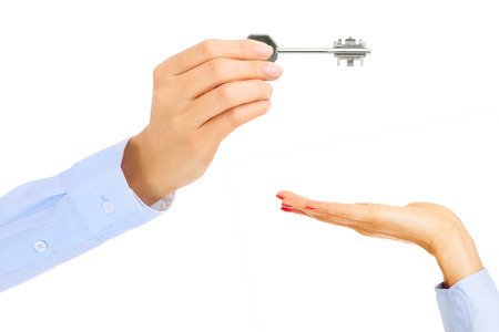 Young woman giving key over white backgroundの写真素材