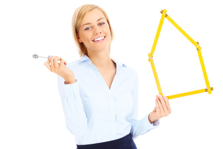 A picture of a real estate agent showing the key and yellow measureの写真素材