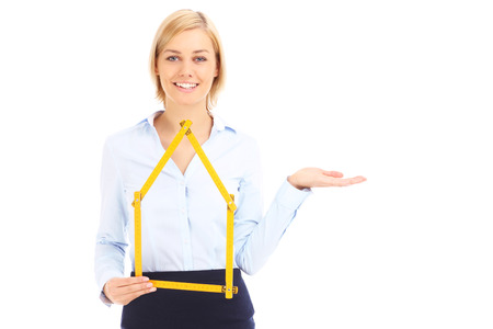 A real estate agent showing yellow measure and pointing over white backgroundの写真素材