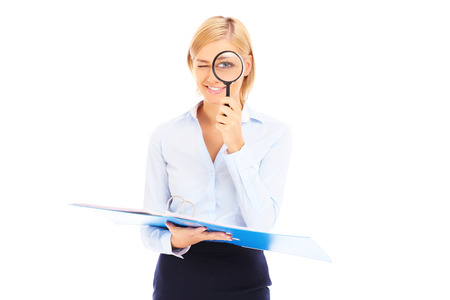 A picture of a young businesswoman with documents and magnifierの写真素材