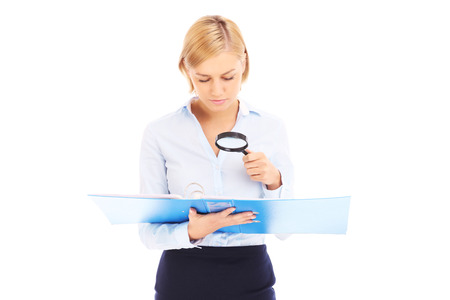 A picture of a young businesswoman with documents and magnifierの写真素材