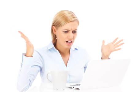 A picture of an angry businesswoman with a laptop over white backgroundの写真素材
