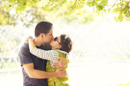 A picture of a kissing couple in the park and copy space on the rightの写真素材