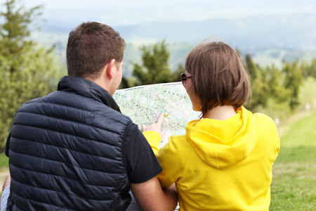 A picture of a young couple with a map in the mountains in Polandの写真素材