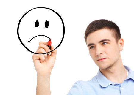 A picture of a businessman drawing a sad faceの写真素材