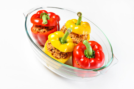 A picture of an unbaked yellow and red stuffed peppers served in a heatproof glassの写真素材