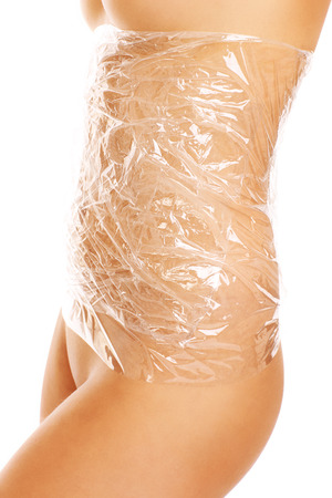 A picture of female belly wraped with foil over white backgroundの写真素材