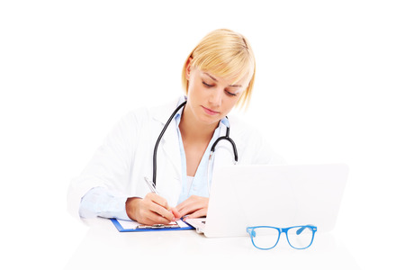 A picture of a young doctor with laptop and documents over white backgroundの写真素材