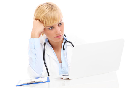 A picture of a sad doctor with laptop and documents over white backgroundの写真素材