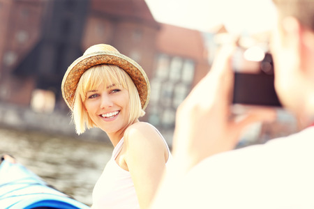 A picture of a young couple taking pictures in kayaks on Motlawa River in Gdanskの写真素材
