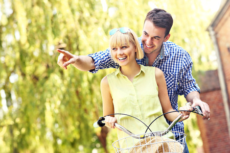 A picture of a happy couple spending free time on bikes in the parkの写真素材