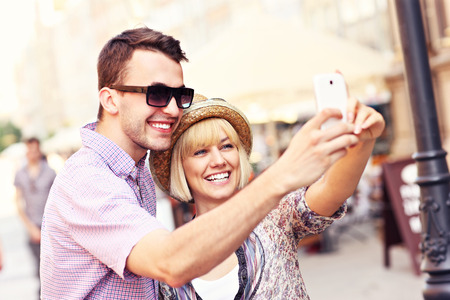 A picture of a happy couple taking a picture of themselves while sightseeingの写真素材