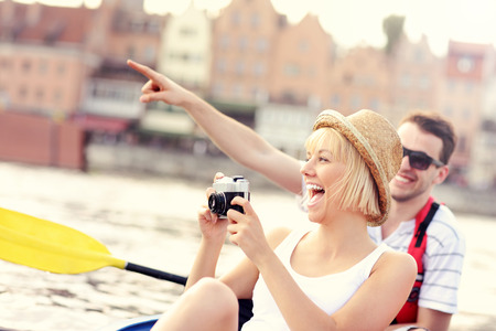 A picture of a young couple taking pictures in a canoeの写真素材