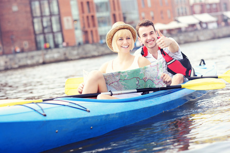 A picture of a young couple with a map in a canoeの写真素材