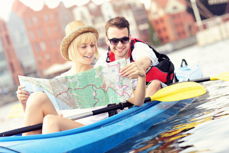 A picture of a young couple with a map in a canoeの写真素材