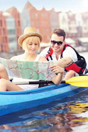 A picture of a young couple with a map in a canoeの写真素材