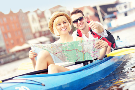 A picture of a young couple with a map in a canoeの写真素材