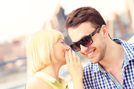 A picture of a woman whispering to boyfriendの写真素材