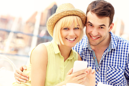 A picture of a happy couple using a cellphone togetherの写真素材