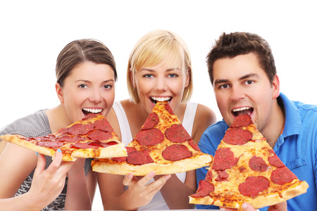 A picture of a group of friends eating big pizza slices over white backgroundの写真素材