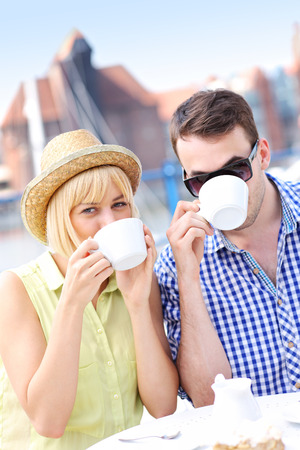 A picture of a young couple drinking coffee in an outside cafe in Gdansk marinaの写真素材