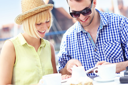 A picture of a young couple reading a guide in a restaurantの写真素材