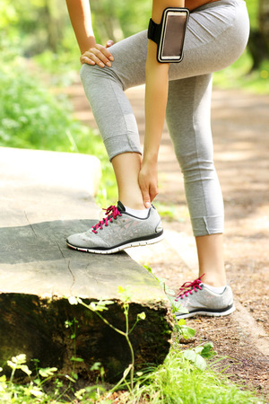 A picture of a jogger having problems with ankle in the forestの写真素材