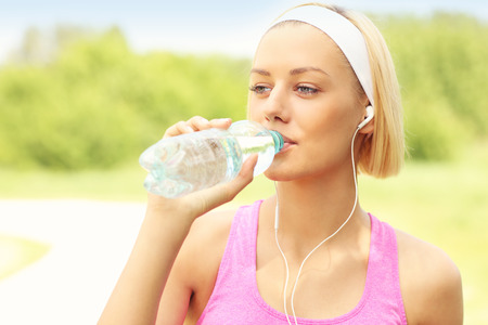 A picture of a runner drinking water in the parkの写真素材