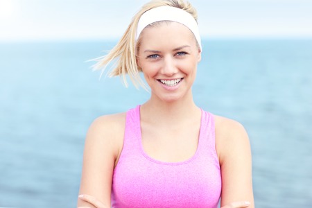 Young Woman in pink sports bra over seaの写真素材
