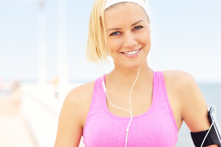 Portrait of younk fit woman on the pier in pink braの写真素材