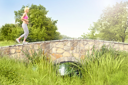 A picture of a runner crossing the bridge in the parkの写真素材