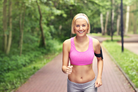 A picture of a happy woman running in the parkの写真素材