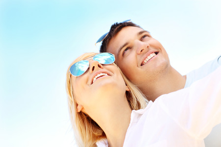 A portrait of a young happy couple over blue skyの写真素材