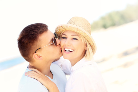 A picture of a man kissing a woman at the beachの写真素材