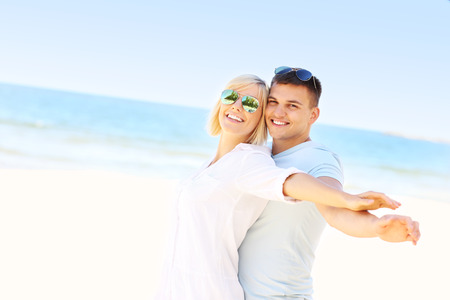 A picture of a young romantic couple hugging at the beachの写真素材