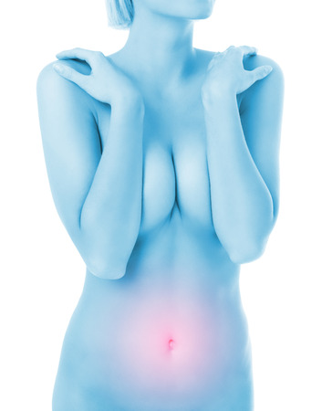 A midsection of a woman with stomach ache over white backgroundの写真素材