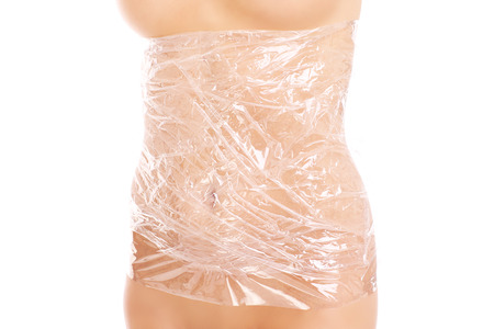 A picture of woman's body wrapped in foil over white backgroundの写真素材