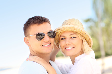 A picture of a romantic couple looking to the camera at the beachの写真素材
