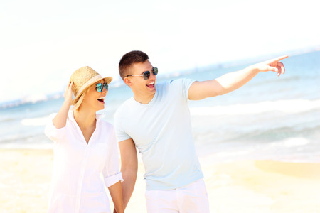 A picture of a young romantic couple walking at the beachの写真素材