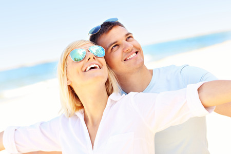 A picture of a young romantic couple hugging at the beachの写真素材