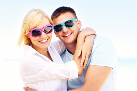 A picture of a young romantic couple hugging at the beachの写真素材