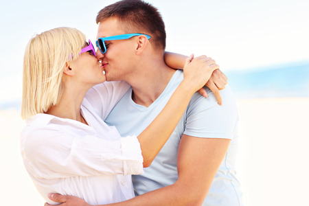 A picture of a young romantic couple kissing at the beachの写真素材