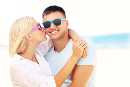 A picture of a woman kissing a man at the beachの写真素材
