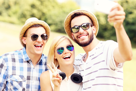 A picture of a group of friends taking a picture in the parkの写真素材
