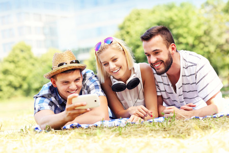 A picture of a group of friends taking selfie in the parkの写真素材