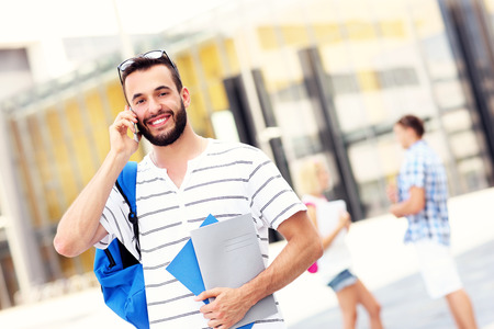A picture of a student talking on the phone in the campusの写真素材